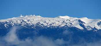  snow-covered peak with observatory domes