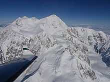 An aerial view of Mount McKinley. An airplane wing is visible in the lower-left corner.