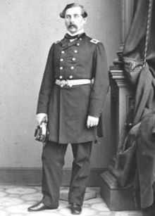 Officer with moustache in dark dress military uniform with long coat