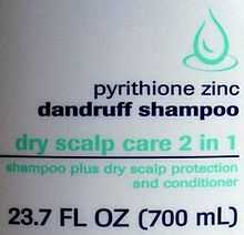 White slightly curved plastic with a green line drawing of a drop, the text "pyrithione zinc dandruff shampoo" in dark blue with "dry scalp care 2 in 1" in green, then a blue line. Underneath it is "shampoo plus dry scalp protection and conditioner" in smaller green type, and finally "23.7 FL OZ (700 mL)" in larger blue type