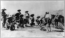  A group of 14 armed men, 8 of them crouching down, in sombreros and holding rifles