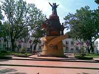 Red-and-brown statue of people on a yellow base