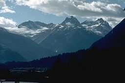 A cluster of jagged mountains rising over the surrounding vegetated landscape.