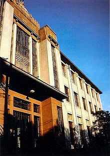 Front of three-story building against a blue sky