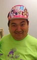 A smiling Asian man in a cap