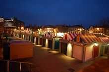 Parallel rows of market stalls with multi-coloured roofs