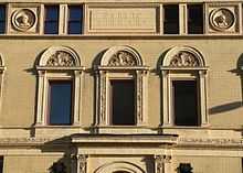 Section of wall.  At top, rectangular panel reading "PVBLIC LIBRARY".  Below, three windows terra-cotta ornamentation around them.