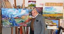 A photograph depicting Italian expressionist painter Paolo Salvati and some of his works in the studio