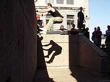 Man jumping off the top of a wall
