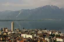 Looking past a city towards a lake, with mountains behind