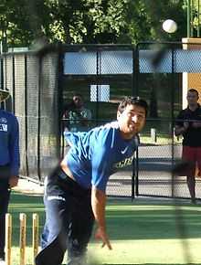 A man wearing a dark-blue shirt and navy or black trousers.