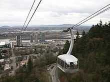 View over the river from one tram while the other passes in the opposite direction.