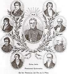Allegoric images of the 7 members of the Primera Junta, arranged in a scheme freely similar to the Argentine coat of Arms. An icon of the president of the Junta is in a big oval in the middle, with a sun over it. A crown of laurel surrounds it, with attached smaller ovals with the icons of the other members of the Junta.