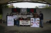 Bangladeshis of all ages holding signs in a Park in Taiwan