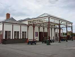 Large white wooden building with a large glass canopy