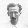 A black-and-white portrait photograph of a moustachioed gentleman with dark, curly hair.