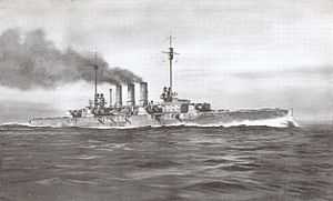 A large gray warship steams at high speed in choppy water; thick black smoke pours from three tall smoke stacks in the middle of the ship