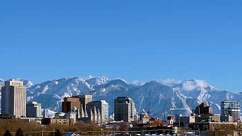 View of a city with snow capped mountains in the background