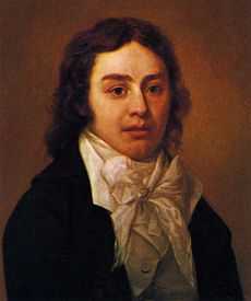 Half-length portrait of man wearing a black jacket and white shirt with an elaborate white bow at the neck. He has wavy, medium-length brown hair.
