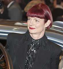 A red-haired woman is seen sporting a black outfit.