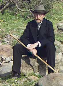 Prokudin-Gorsky seated on a log