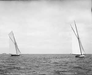 Black and white photograph of two yachts racing under full sail