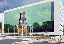 Glass-front building behind a line of flags