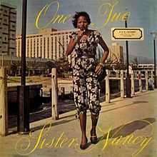 The cover of the 1982 album, "One, Two" featuring Sister Nancy walking in a dress