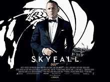 The poster shows a man wearing a tuxedo and holding a gun, standing in front of an image that looks like it was taken from the inside of a gun barrel, with the London skyline visible behind him. Text at the bottom of the poster reveals the film title and credits.