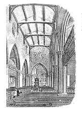 Interior of a church with a high vaulted ceiling, gallery balconies along the sides, and a large coat of arms on the chancel arch