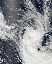 Satellite image of a weakening tropical cyclone. It appears elongated, and only has spiralling convection.