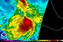 Colorized infrared satellite image of a tropical storm near the west coast of central Mexico. Intense convective activity, such as strong thunderstorms, are depicted by areas of bright red, concentrated around the center of the storm.