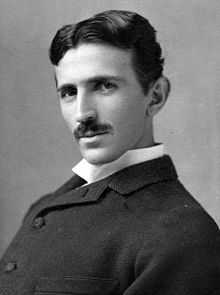 head-and-shoulder shot of slender man with dark hair and moustache, dark suit and white-collar shirt