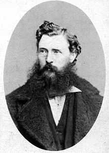 A dark-haired man with a scruffy beard