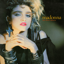 Madonna wearing crucifix earrings and multiple plastic wrist bracelets around right wrist