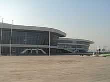 partial view of a curvy white building with long airport-style windows