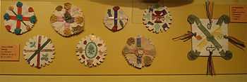 Photograph of eight home-made badges composed of variously coloured crosses and saltires.