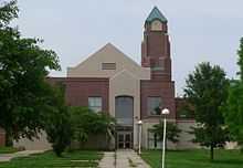 1990s brick building with square pyramidal-topped steeple, clear glass windows