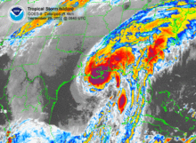 Colorized image of a hurricane with no eye, but clear banding features. Darker magenta shades indicate strong thunderstorms, and lighter, bluer shades indicate weaker convection.