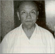 A bald man, wearing a white T-shirt