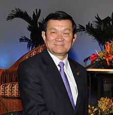 lower half of Truong Tan Sang standing in a dark suit, with a blue tie and white shirt.