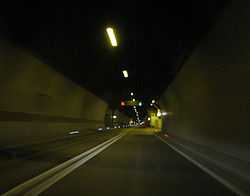 Inside of Mala Kapela Tunnel when operated as a single tube tunnel featuring a double solid line dividing the traffic lanes and variable traffic signs indicating two way traffic in the tunnel.