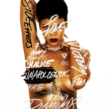 A picture of a woman with short black hair and dark lipstick, standing in front of a white back ground her nude torso is covered in graffiti-style words such as "Side Effects" in black font on her arm, the rest of words are in white/grey font "Victory", "Chalice", "Diamonds", "Navy", "7", "#R7", "Diamonds", "Happy", "Censored", "Love", "Roc", "Fun", and "Fearless" as well as "Unapologetic" covering her left side nipple, she also has very thin jewelry, a pair of small earrings and two thin chains one around her neck, the other around her nude torso, also showing her tattoo of the Egyptian goddess Isis between her cleavage.<