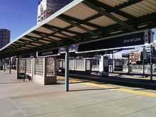 Empty station platform with signage and canopy visible.