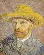 A red-bearded man with a straw hat on gazes to the left.