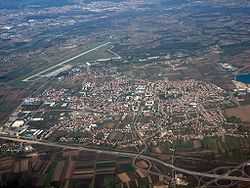 An aerial view of motorway cloverleaf interchange and airport runway