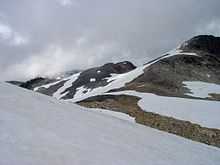 Rugged landscape of rock covered with snow on a cloudy day.