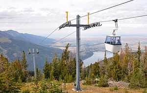 A gondola begins its descent from Mount Howard. Wallowa Lake and the Wallowa Valley are to the right.