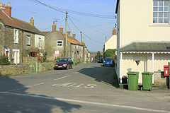 Street scene. Houses to left and right of road junction.