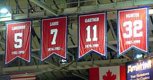 Four red banners with large numbers hang from the ceiling of an arena